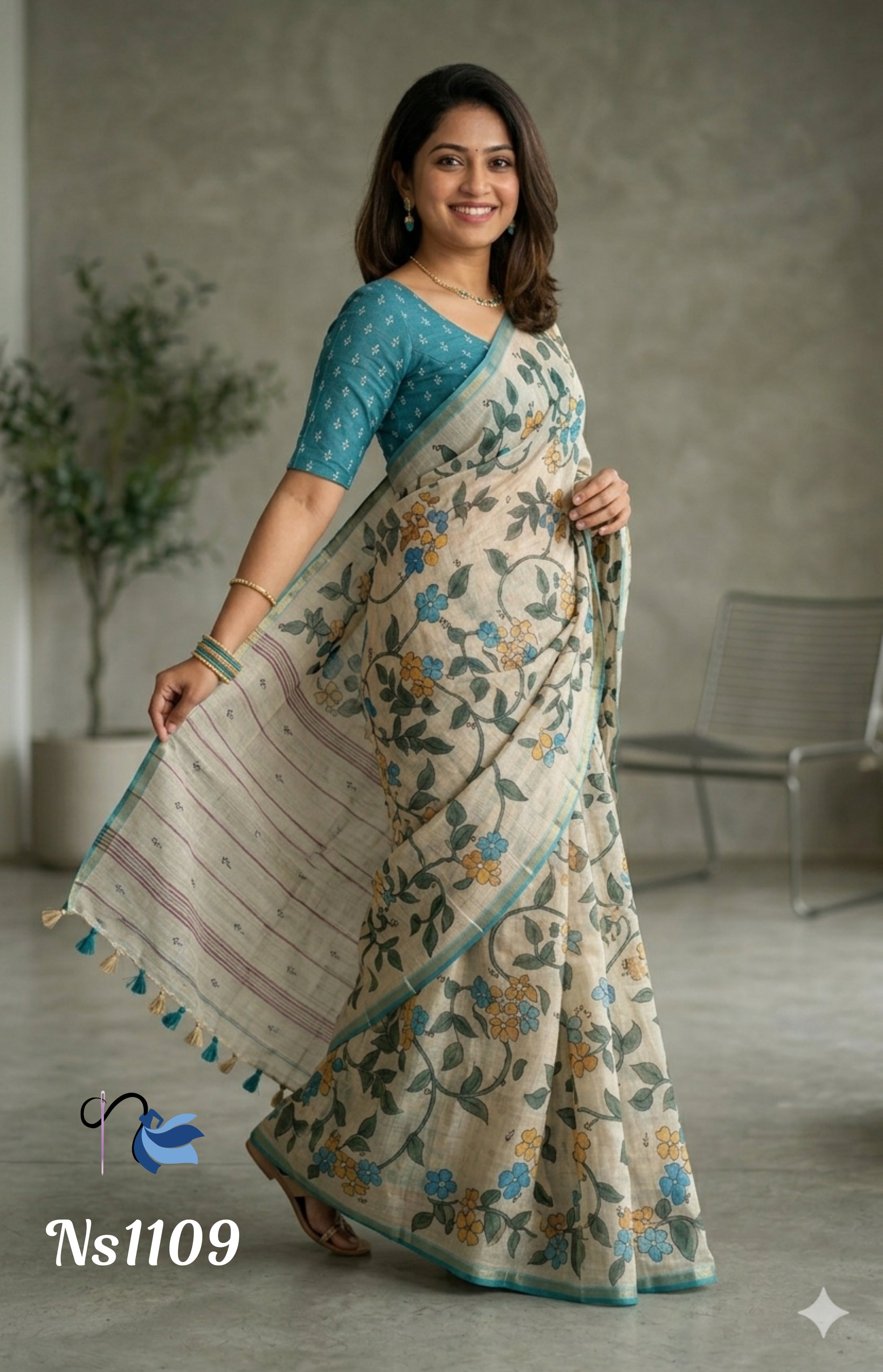Woman wearing an off-white linen saree with a green leaf and blue-yellow floral vine print, paired with a teal blue patterned short-sleeve blouse.