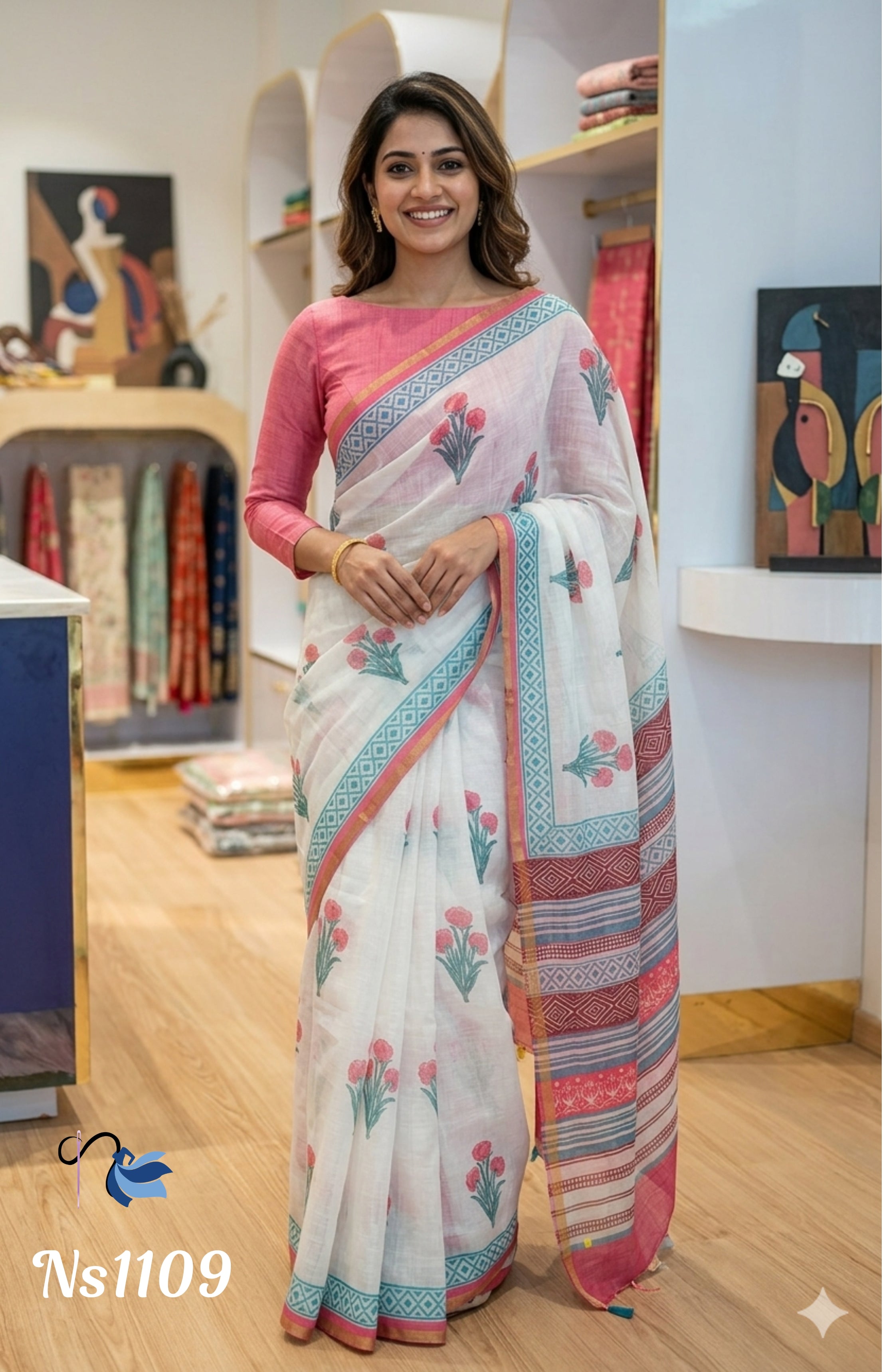 Woman wearing a white saree with pink and blue patterns in an indoor setting.